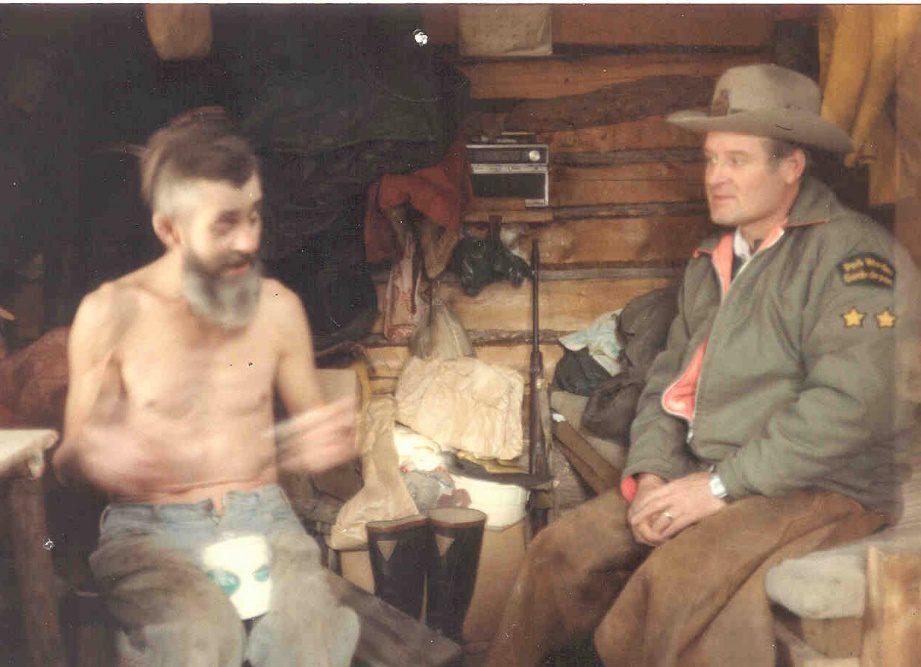 Trapper Bill rolling a smoke with Chief Park Warden Don Dumpleton. Note Old Betsy in the background.